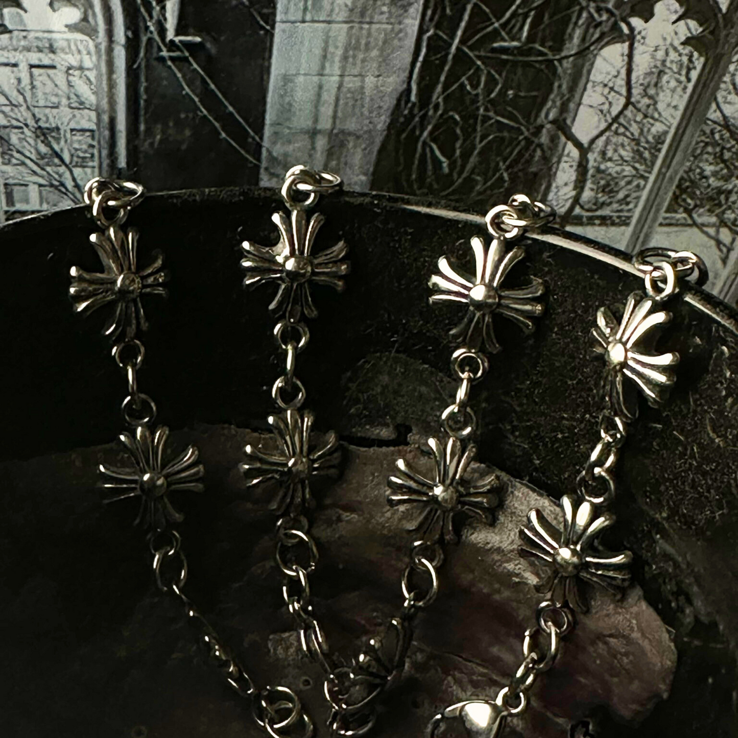 Varias pulseras de acero inoxidable 'Follow Bracelet' con diseño de cruces en relieve, de la marca Follow God, exhibidas en una superficie oscura