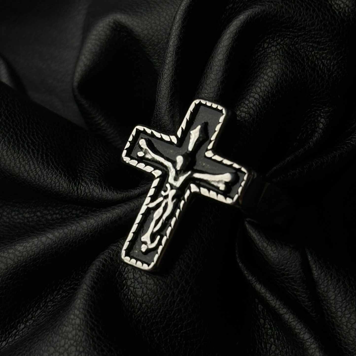 Anillo de acero inoxidable tipo sello 'Follow Ring Big Cross' con diseño de cruz en relieve, de la marca Follow God, exhibido sobre cuero negro