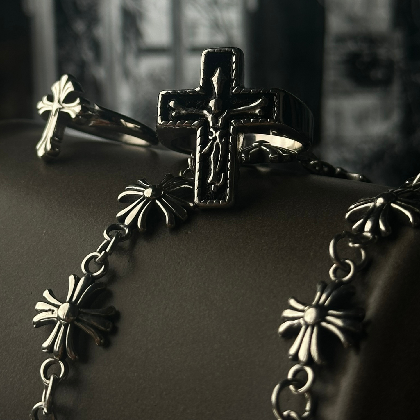 Dos pulseras de acero inoxidable 'Follow Bracelet' con diseño de cruces en relieve, acompañadas por los anillos 'Follow Ring Big Cross' y 'Follow Ring Lil Cross', de la marca Follow God